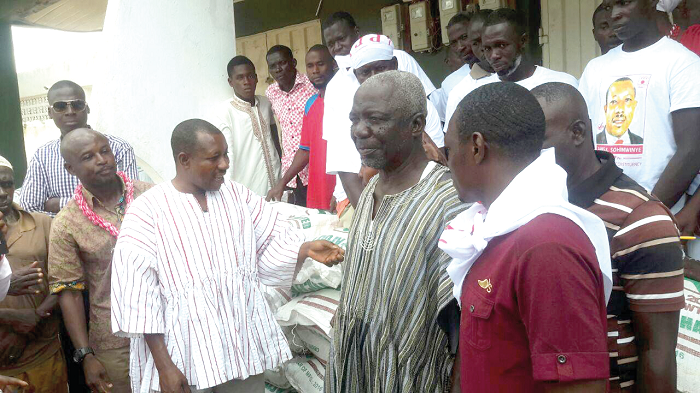  Mr James Sohimnye (in white smock) presenting the items to the farmers